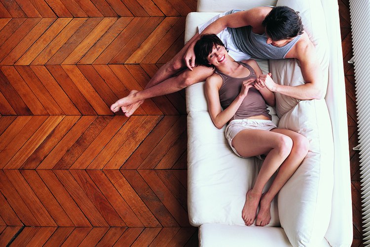 Pareja recostada sobre un sofá.