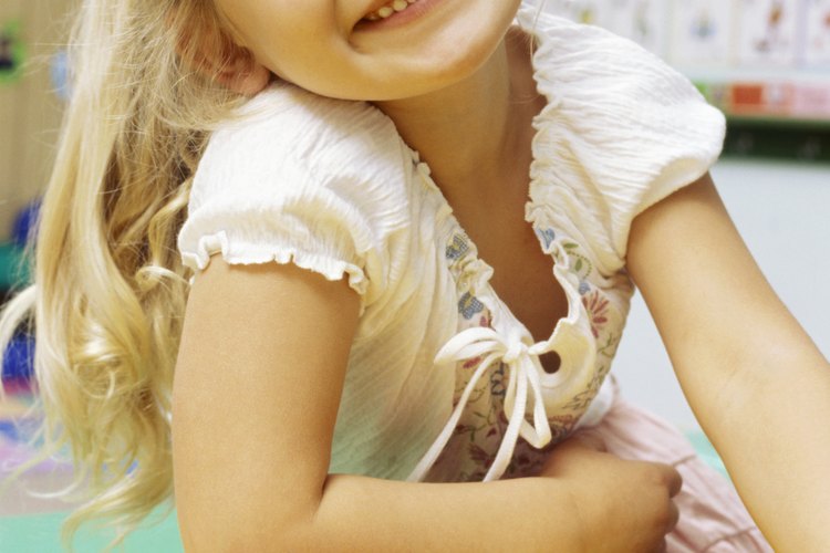 Niña de preescolar juega con las letras.