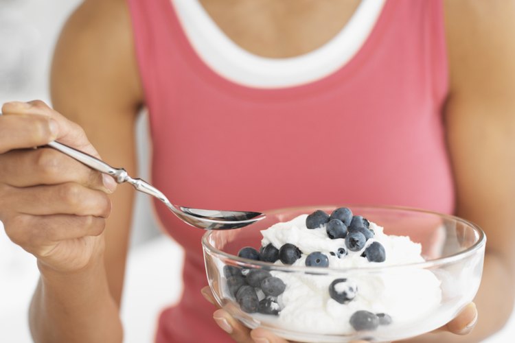 Una mujer comiendo yogurt.