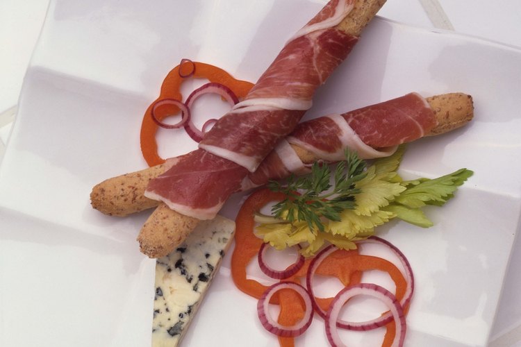 El prosciutto, un jamón curado italiano, se pueden envolver alrededor de un pan grisín.