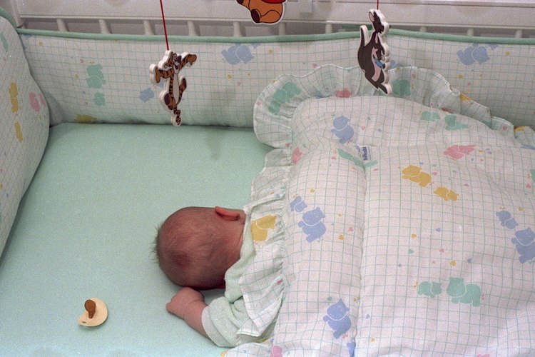 Ángulo superior de un bebé durmiendo en una cuna.