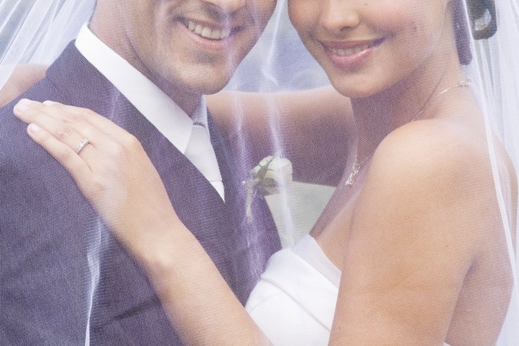 La pareja comparte el velo caído de la novia.
