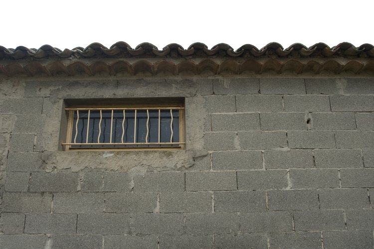 Soluciona las grietas del revoque y otros daños antes de pintar una pared de bloques.