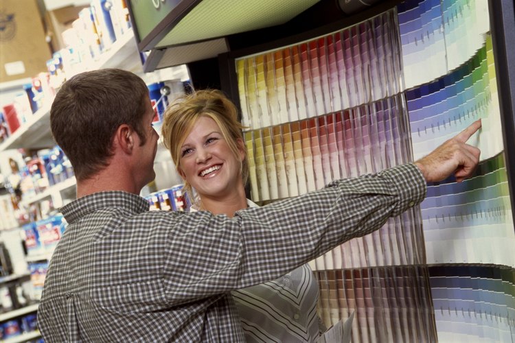 Mujer eligiendo el color de una pintura de látex brillante en la tienda.