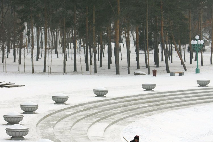 Un limpiador barre la nieve de una carretera en Harbin.