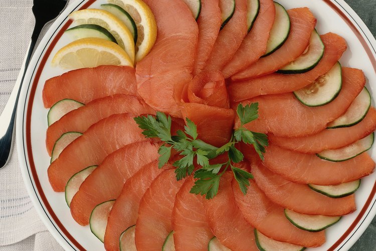 El salmón ahumado sabe delicioso solo con un poco de limón y rodajas de pepinos.