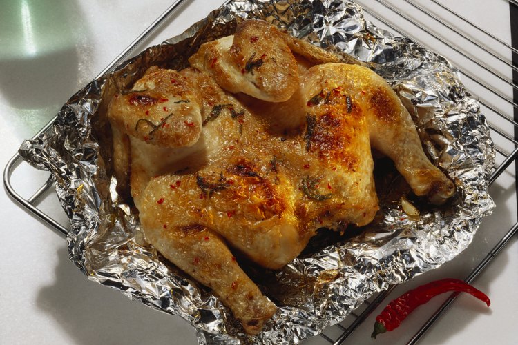 Cocina dos pollos asados para la comida de tres noches.
