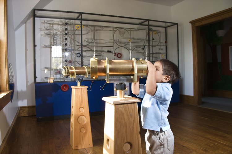 Un niño observa a través de un telescopio en un museo.