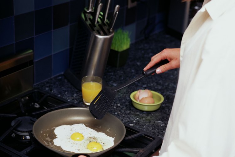 Utiliza la espátula para romper la yema durante la cocción para huevos fritos con yema dura.