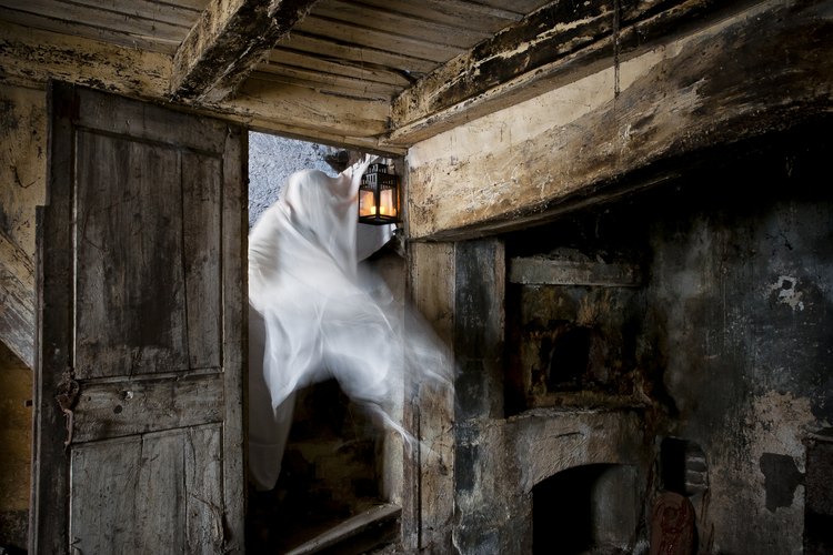 La figura de un fantasma se hace presente en una vieja habitación de madera.