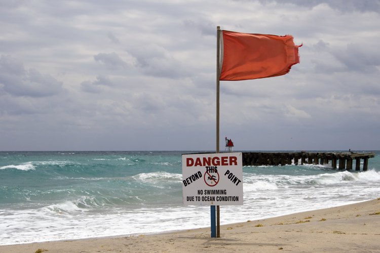 Una bandera de advertencia roja cerca del agua.