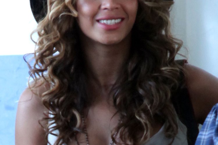 Beyonce lleva el pelo castaño o rubio arriba con una capa inferior negra.