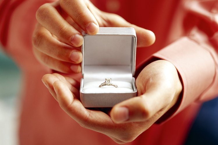 Hombre sosteniendo un anillo de diamantes.