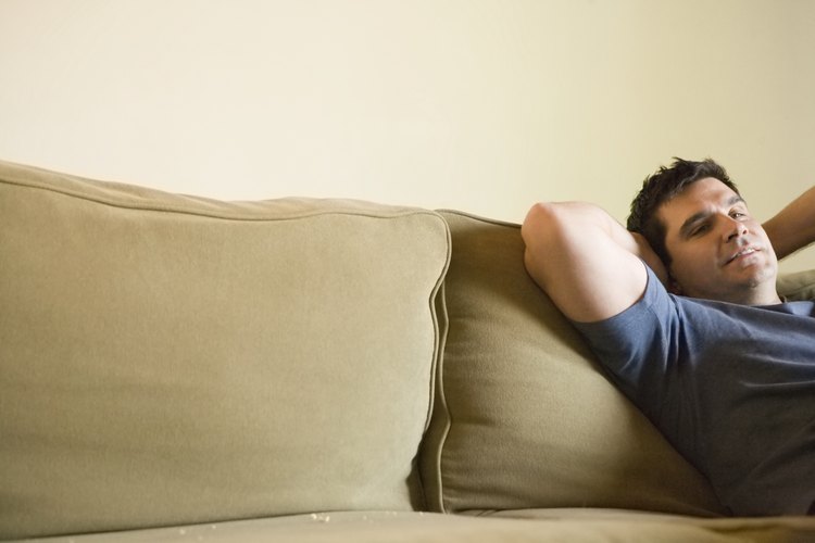 Hombre recostado en un sillón.