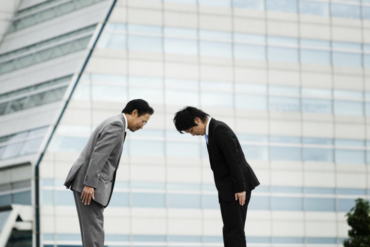 Dos hombres de negocios saludándose con una reverencia en Japón