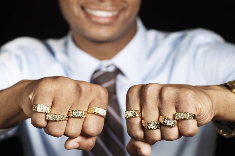 Hombre con muchos anillos de oro en los dedos.