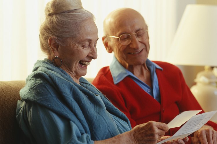 Pareja de ancianos leyendo una vieja carta de viaje