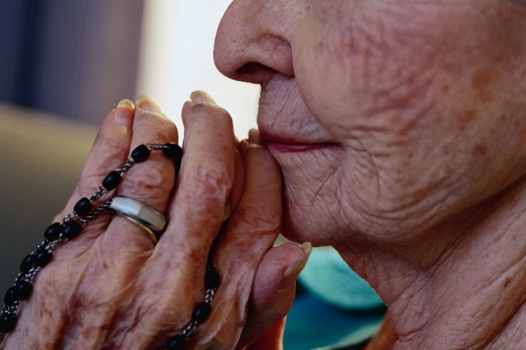 Una mujer reza el santo rosario mientras contempla los misterios de la vida de Cristo.