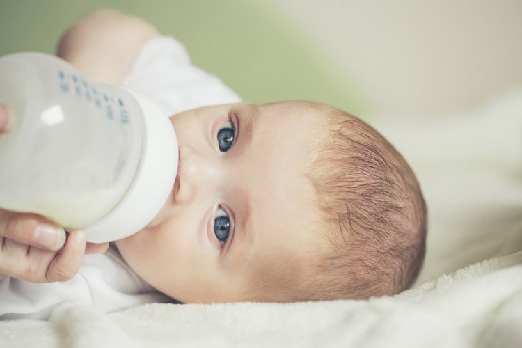 Bebé tomando biberón de leche.
