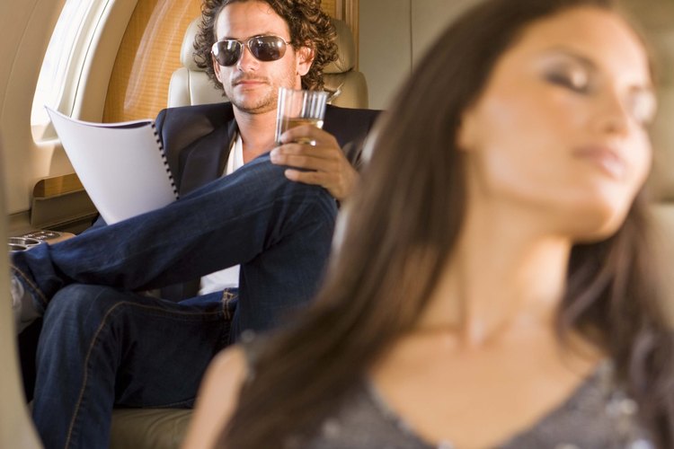 Algunos pasajeros duermen sentados en un avión.