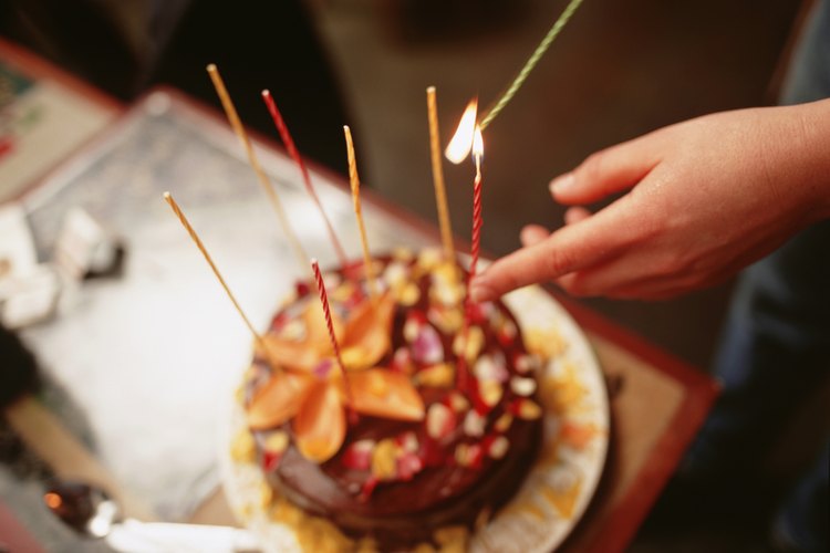 Mujer encendiendo las velas del pastel.