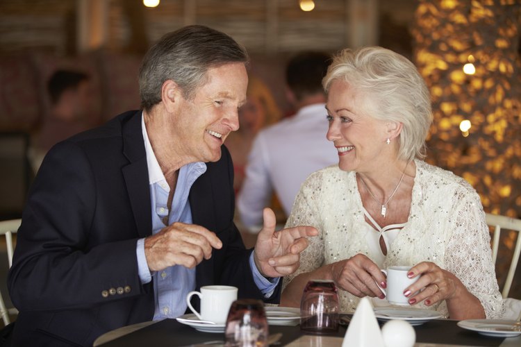 Dos personas felices conversan en una mesa apartada de un restaurante.