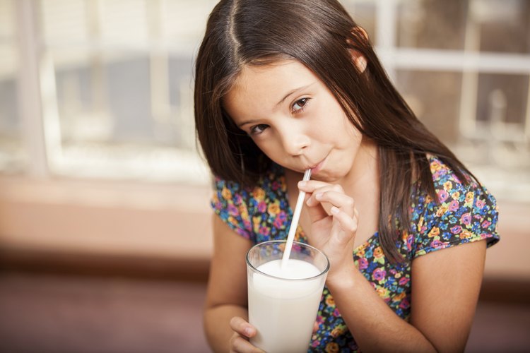 Niña bebiendo un vaso de leche.