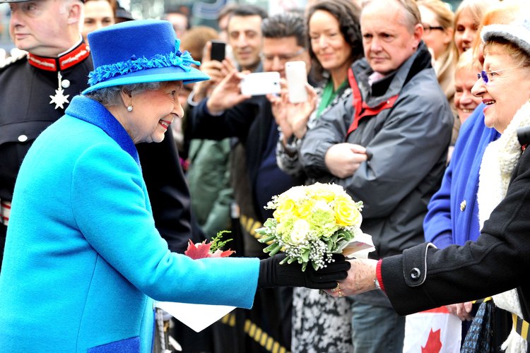 La Reina de Inglaterra recibe flores de un admirador.