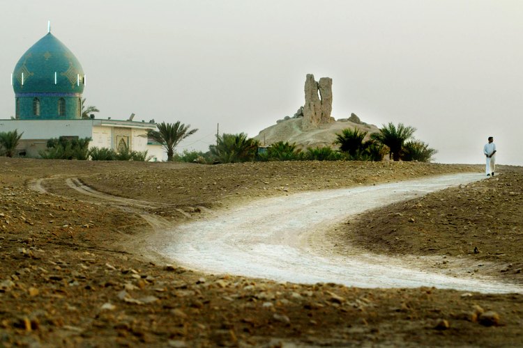 Un camino serpentea a través de un paisaje mesopotámico por un antiguo santuario.