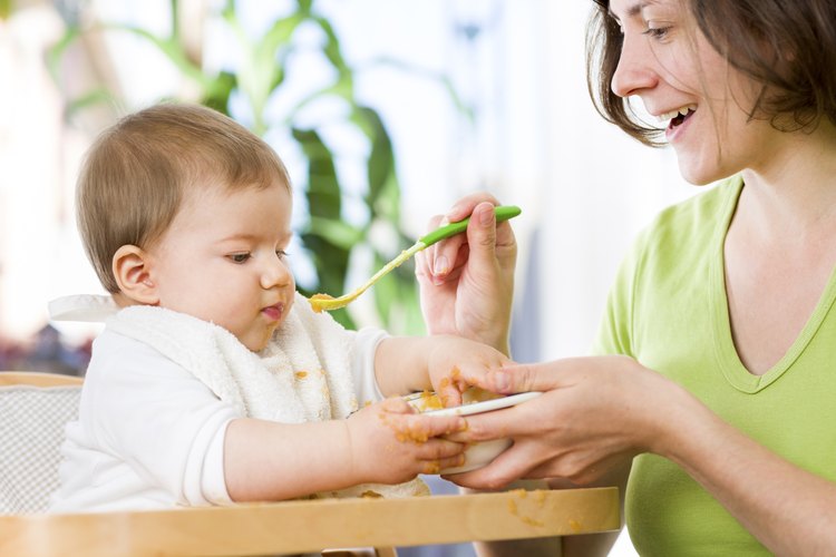 Madre alimentando a un bebé de 12 meses de edad.