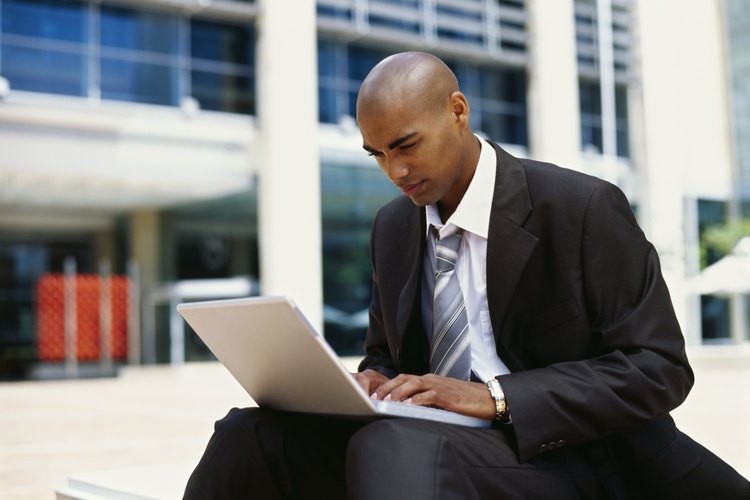 Hombre escribiendo en una computadora portátil.