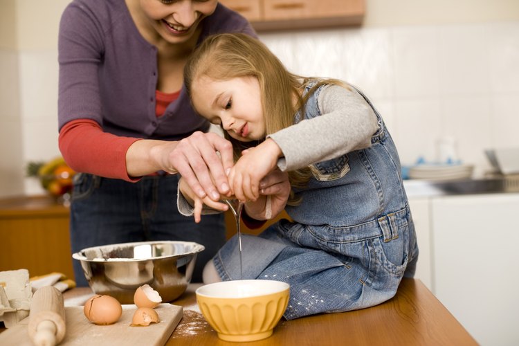 Enséñale las habilidades básicas para cocinar cuando estén haciendo golosinas para el Día de San Valentín.