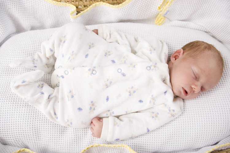 Bebé durmiendo en un moisés.