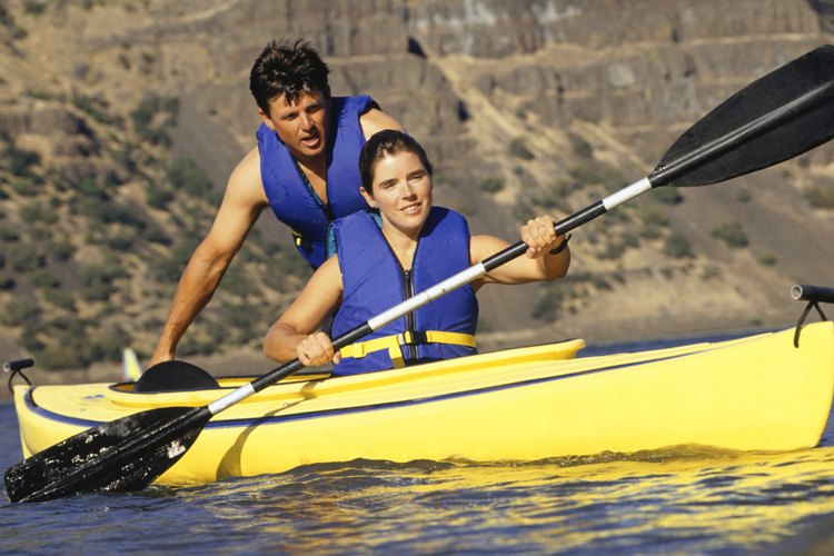Una pareja agotada remando un kayak.