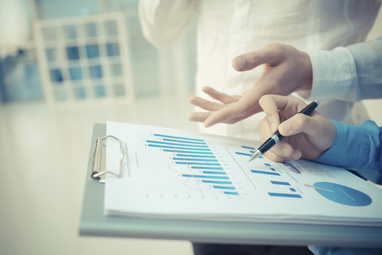 Dos personas analizan datos estadísticos en una planilla