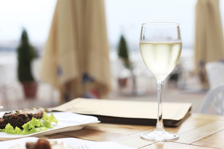Una copa de vino blanco en la terraza de un hotel.