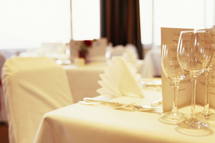 Crea decoraciones para una mesa de boda impresionante con servilletas dobladas elegantemente.