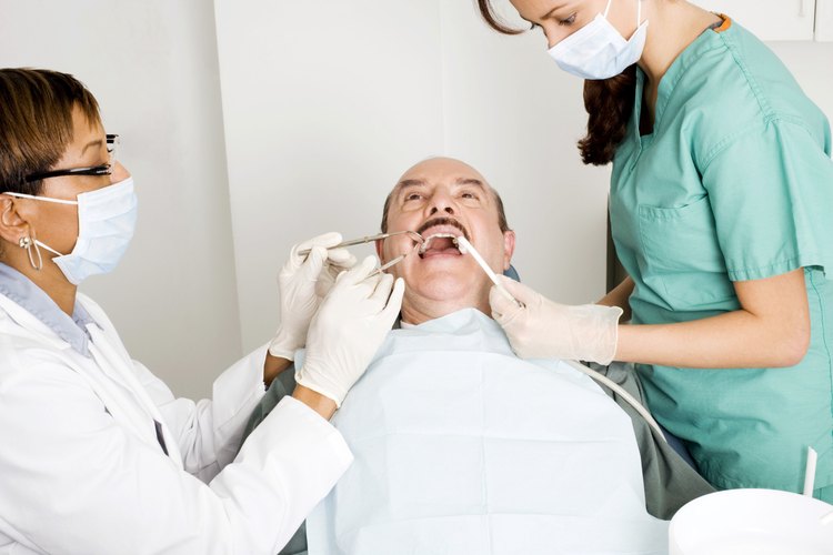 Un asistente dental ayuda al dentista durante un examen.