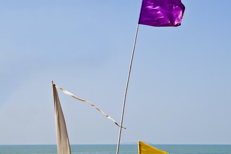 Las banderas de advertencia púrpura y amarilla en la playa.