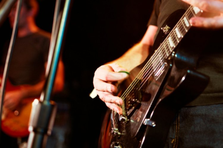 Este guitarrista coloca los dedos en posición estirada.