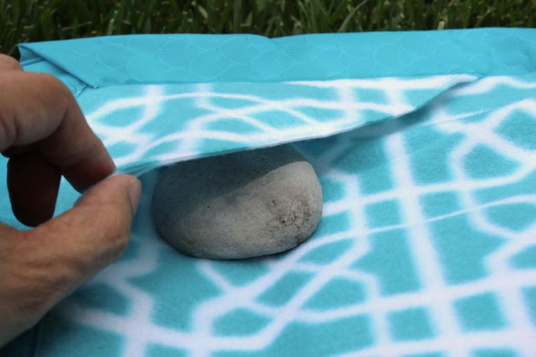 Pon contrapesos de rocas en las esquinas de la manta.