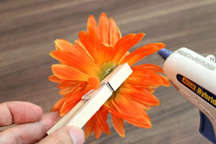 Adhiere las pinzas para la ropa a las flores de seda.