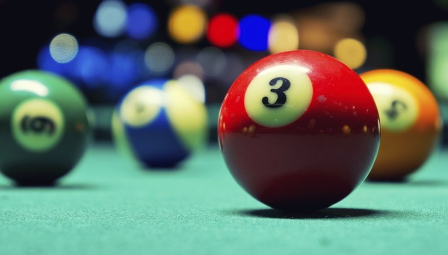 The felt of the pool table lets the ball roll smoothly.