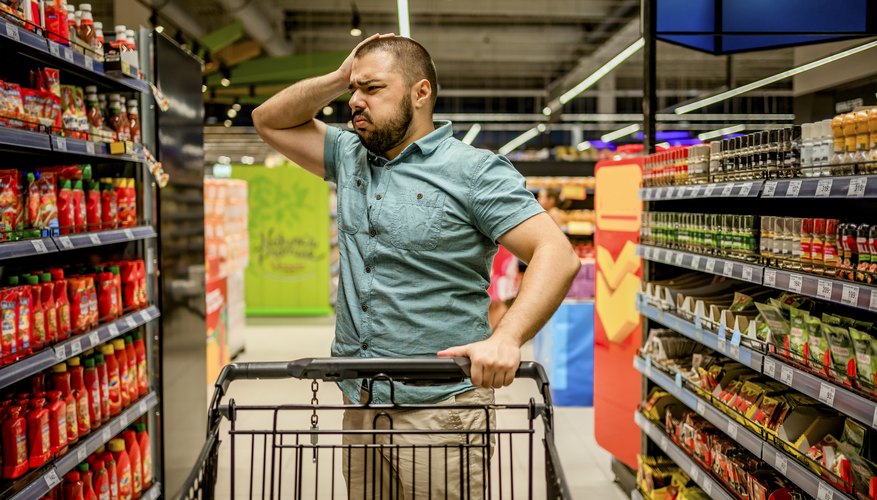 Hombre en el pasillo de un supermercado en Arizona preguntándose qué puede comprar con su tarjeta EBT.