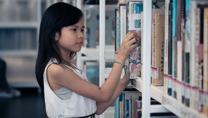 Woman in white tank top holding book.jpg
