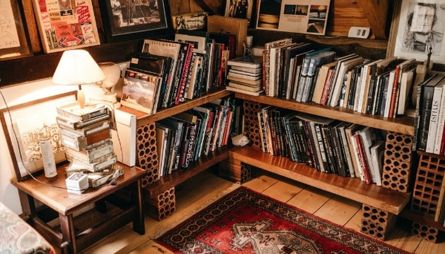 Assorted books in shelf near lighted table lamp.jpg