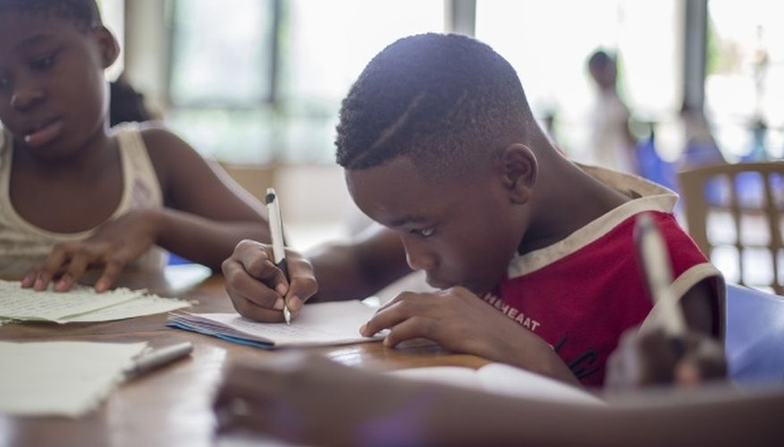 Boy writing on printer paper near girl.jpg