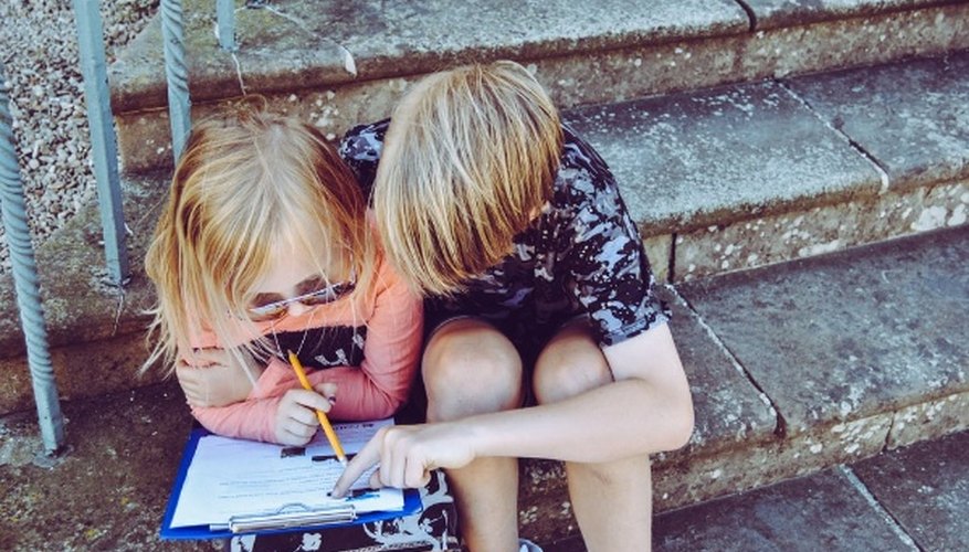 Boy and girl answering questions on white paper.jpg