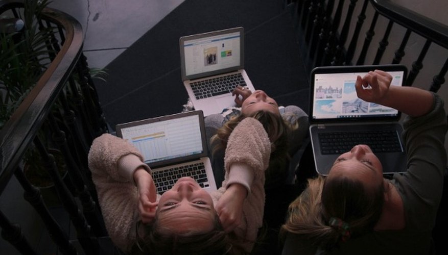 Three person using laptops while sitting on ladder.jpg