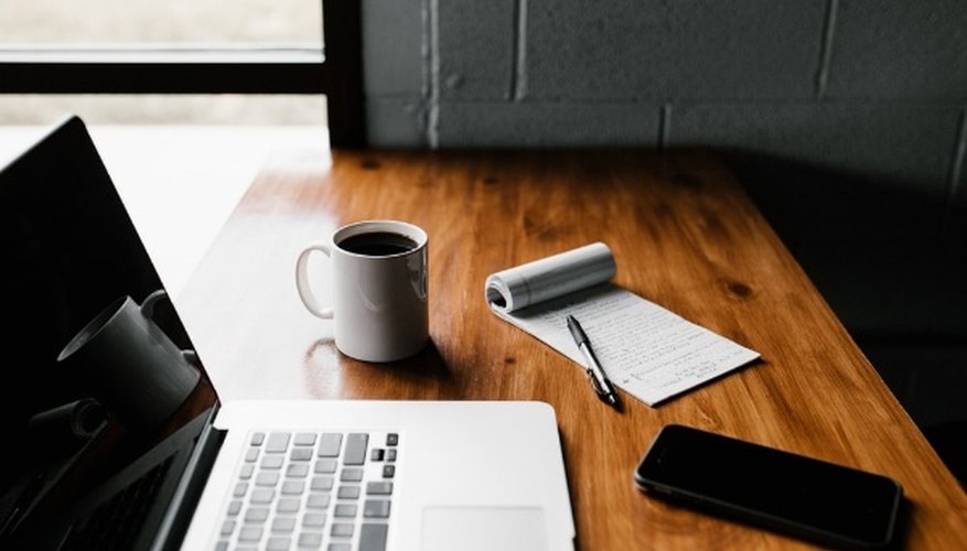 Macbook pro, white ceramic mug,and black smartphone on table.jpg